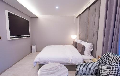 a bedroom with a bed and a flat screen tv at 사직 덴바스타 시그니처 호텔 in Busan