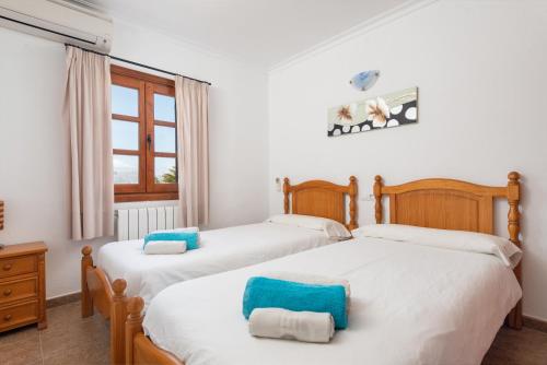 2 łóżka pojedyncze w pokoju z oknem w obiekcie Villa Pou d,Ambroitx, pool and sea views in Alcudia w Alcudii