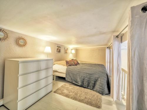 ein Schlafzimmer mit einem Bett und einer Kommode in einem Zimmer in der Unterkunft Biarritz's Centre Studio in Biarritz