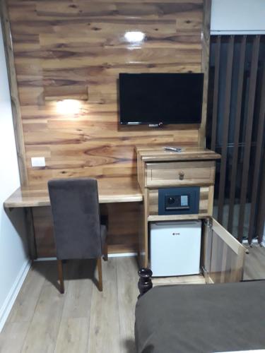 a room with a desk with a television on a wall at Vila ZLATARSKA PAHULJA in Nova Varoš