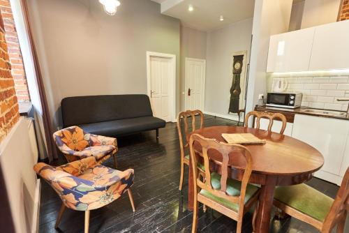 uma sala de estar com uma mesa e cadeiras e um sofá em Apartament Patisserie by Good Time em Lódź