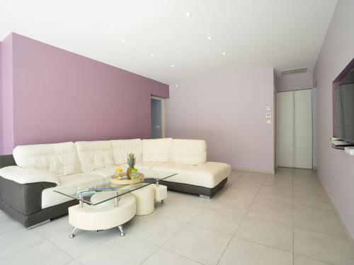 a living room with a white couch and a table at Holiday Home Villa du Littoral by Interhome in Le Grau-dʼAgde