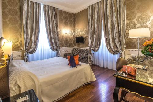 a bedroom with a bed and a chair and a table at Albergo del Senato in Rome