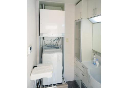a white kitchen with a sink and a washer and dryer at Kasane / The Family Villa in Ishigaki Island