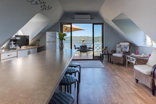 una cucina e un soggiorno con un grande bancone e sedie di 6 On Protea a Knysna