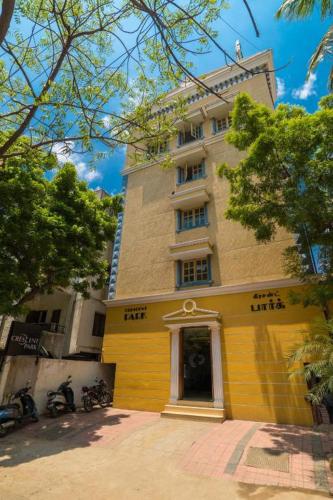 a yellow building with motorcycles parked in front of it at Crescent Park in Chennai