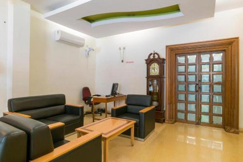 a waiting room with two chairs and a clock at Crescent Park in Chennai