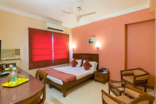 a bedroom with a bed and a red window at Crescent Park in Chennai