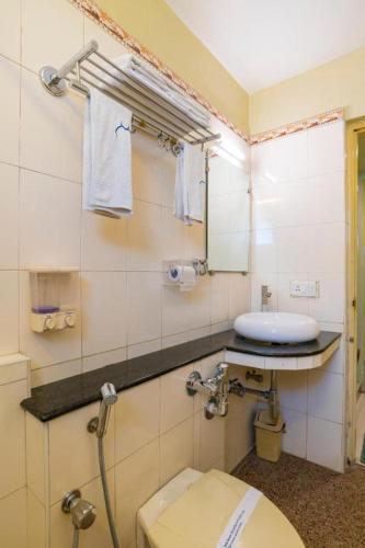 a bathroom with a toilet and a sink and a mirror at Crescent Park in Chennai