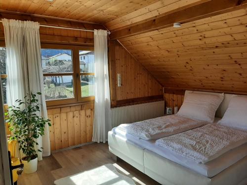 a bedroom with a bed and a large window at Ferienwohnung "Marie's Auszeit" in Bodensdorf