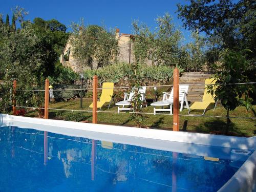 a swimming pool with yellow chairs and a yard at Villa Il Circolo by Interhome in Borselli