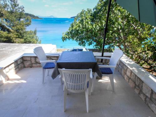 a table and chairs on a patio with a view of the ocean at Holiday Home Bernardi by Interhome in Lumbarda