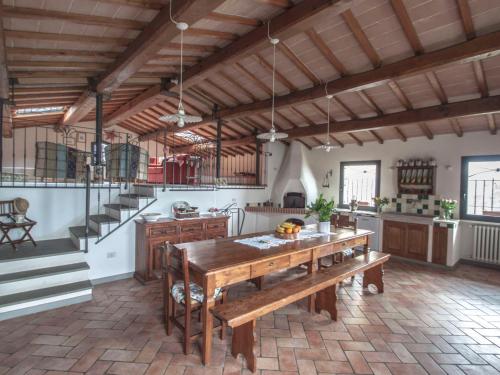 een grote keuken met een houten tafel en een trap bij Villa Il Circolo by Interhome in Borselli