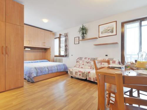 sypialnia z łóżkiem i stołem oraz jadalnia w obiekcie Studio Apt 14 by Interhome w mieście Alba di Canazei