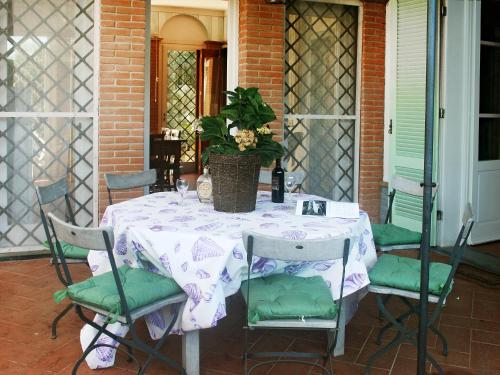 a table with chairs and a potted plant on a porch at Villa Lorenzo by Interhome in Forte dei Marmi