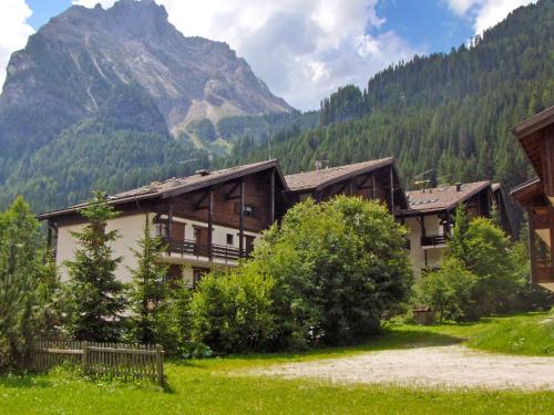 a building with a mountain in the background at Studio Apt 8 by Interhome in Alba di Canazei