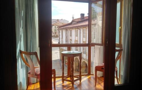 uma janela com uma mesa e cadeiras com vista para uma rua em HOSTAL SANCHO GARCIA em Espinosa de los Monteros