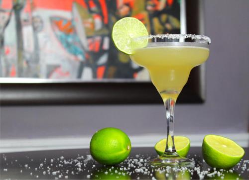 a lime margarita in a martini glass next to limes at 24 Royal Terrace in Edinburgh