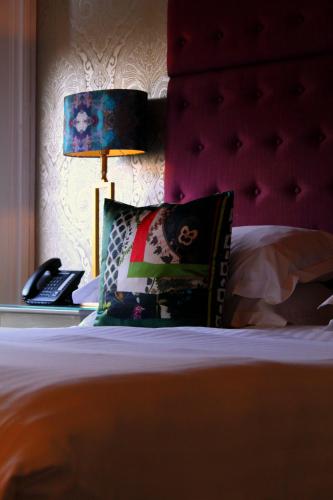 a bed with a lamp and a pillow and a phone at 24 Royal Terrace in Edinburgh