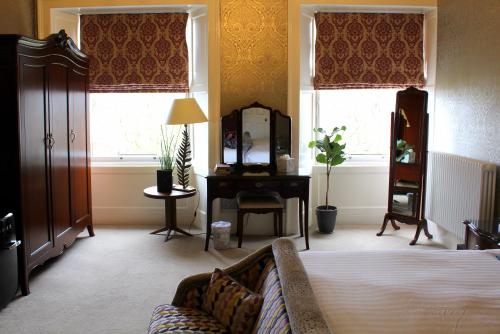 a bedroom with a bed and a desk and a mirror at 24 Royal Terrace in Edinburgh