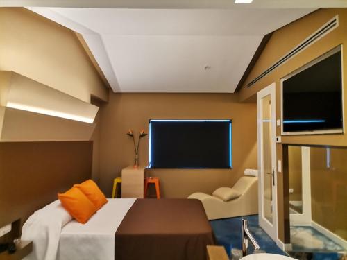 a bedroom with a bed and a flat screen tv at Motel Latino in Llanera