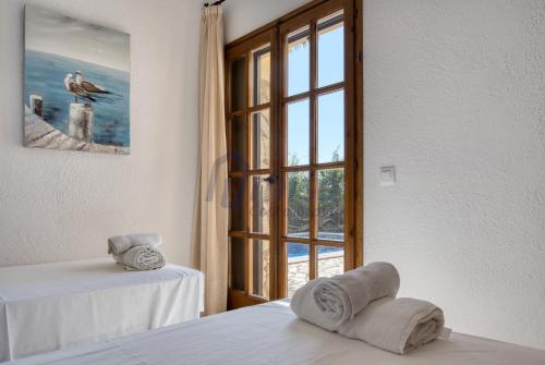 - une chambre avec une fenêtre et 2 serviettes sur un lit dans l'établissement Villa Puig Rosell, à Calonge