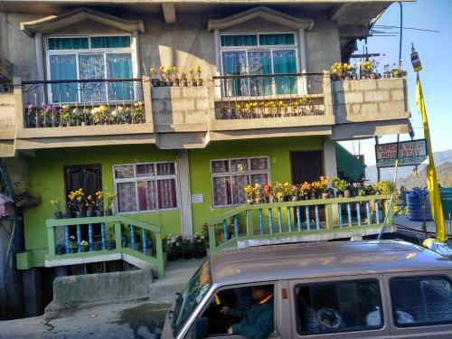 a van parked in front of a building with flowers at Vamoose Lepcha View in Ghum