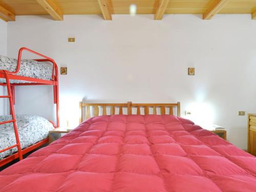 a red bed in a room with two bunk beds at Apartment Villaggio Ladino by Interhome in Mazzin