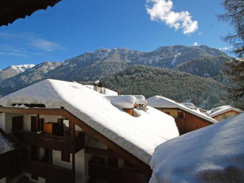 a snow covered roof of a house with mountains in the background at Apartment Villaggio Ladino by Interhome in Mazzin