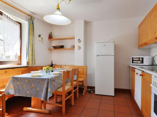 een keuken met een tafel en een witte koelkast bij Apartment Cesa Palua by Interhome in Alba di Canazei