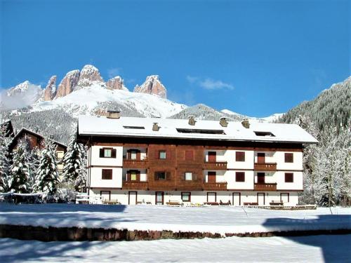 a building in the snow with a mountain at Apartment Cesa Palua by Interhome in Alba di Canazei