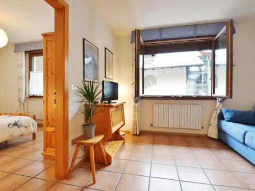 ein Wohnzimmer mit einem blauen Sofa und einem TV in der Unterkunft Apartment Cesa Manzini-2 by Interhome in Canazei