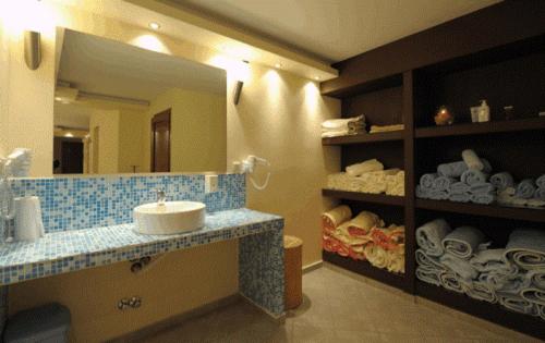 bagno con lavandino e grande specchio di Panorama Spa Hotel a Ouranoupoli