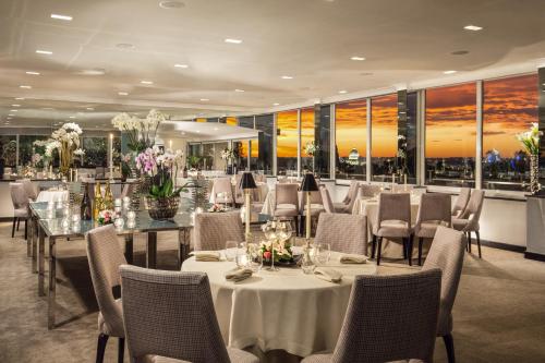 a restaurant with white tables and chairs and windows at Hotel Splendide Royal - The Leading Hotels of the World in Rome