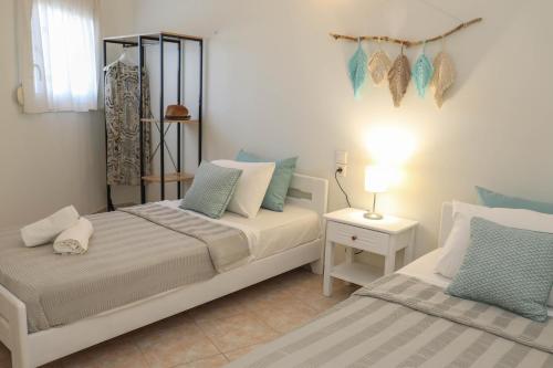 Tramontana House1 في مدينة سكياثوس: غرفة نوم بسريرين مع وسائد زرقاء وبيضاء