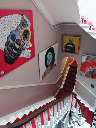 a staircase in a house with art on the walls at 24 Royal Terrace in Edinburgh