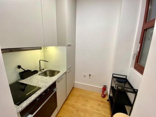a small white kitchen with a sink and a counter at Porto.Leça - Studios and Apts (Apt E) in Leça da Palmeira