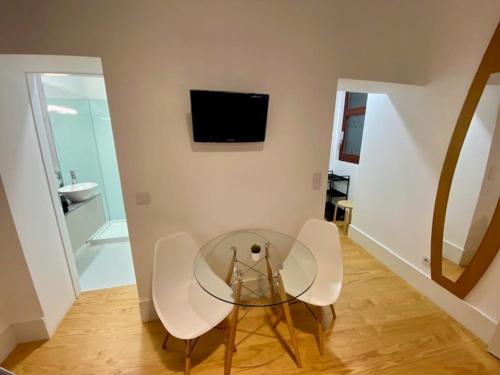 ein Esszimmer mit einem Glastisch und weißen Stühlen in der Unterkunft Porto.Leça - Studios and Apts (Apt E) in Leça da Palmeira