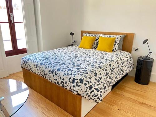 a bedroom with a bed with yellow pillows and a glass table at Porto.Leça - Studios and Apts (Apt E) in Leça da Palmeira
