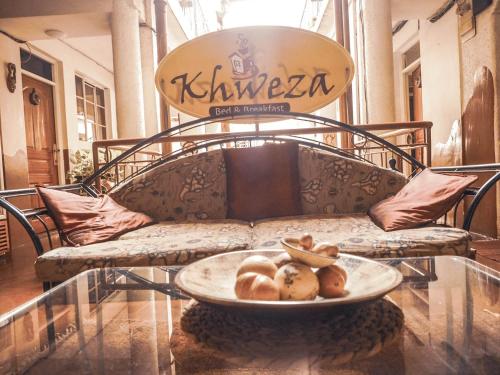 a couch with a plate of food on a table at Khweza Bed and Breakfast in Nairobi