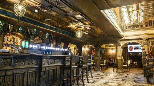 a bar in a room with chairs and a ceiling at Skeffington Arms Hotel in Galway