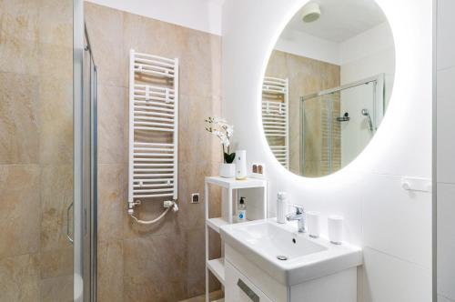 een witte badkamer met een wastafel en een spiegel bij Prima Playa in Międzyzdroje