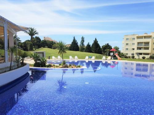
a pool with a blue and white pool table and chairs at Vila Marachique Mariosilvat in Alvor
