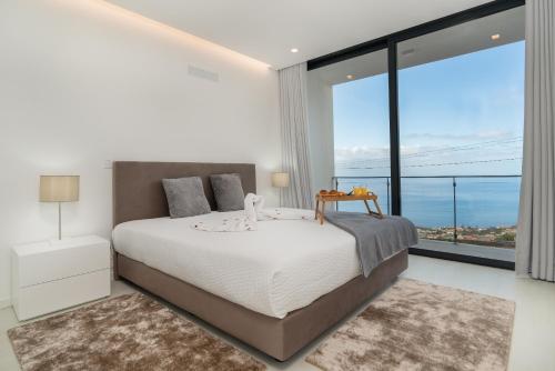 a bedroom with a large bed and a large window at CASA GEORGINA in Calheta