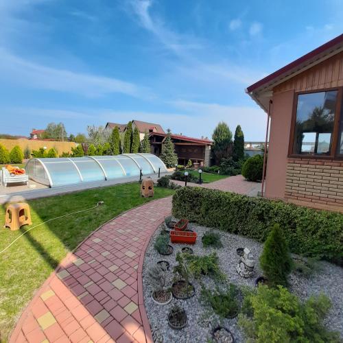 a garden with a brick walkway next to a house at Villa Costa in Sanzhiyka