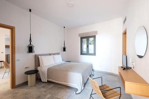 a bedroom with a bed and a desk and a television at Margo Beach Hotel in Gythio