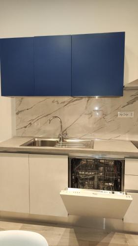 a kitchen with blue cabinets and a sink at Residence Mare Azzurro in Lerici
