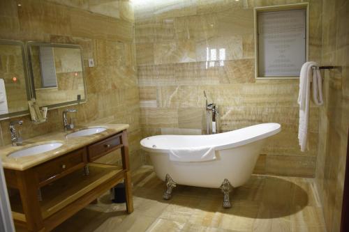 La salle de bains est pourvue d'une grande baignoire et de 2 lavabos. dans l'établissement Hotel Royal Palace, à Douala