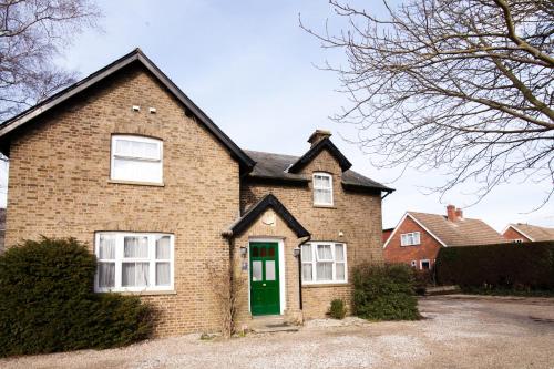 a brick house with a green door at Hunters Meet in Bishops Stortford