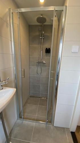 a shower with a glass door in a bathroom at Casa Cappuccino duo studio in Groningen